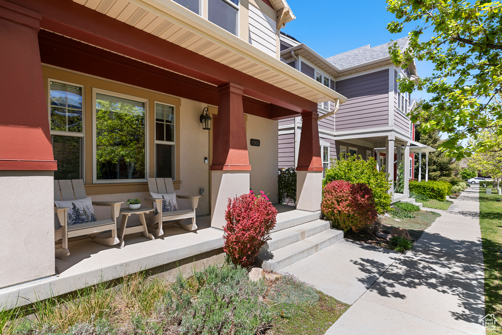 Property entrance featuring covered porch and stucco siding