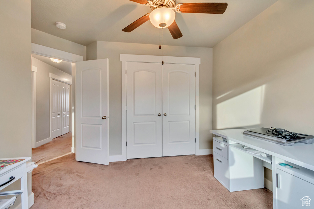 Office area featuring ceiling fan, light colored carpet, and baseboards