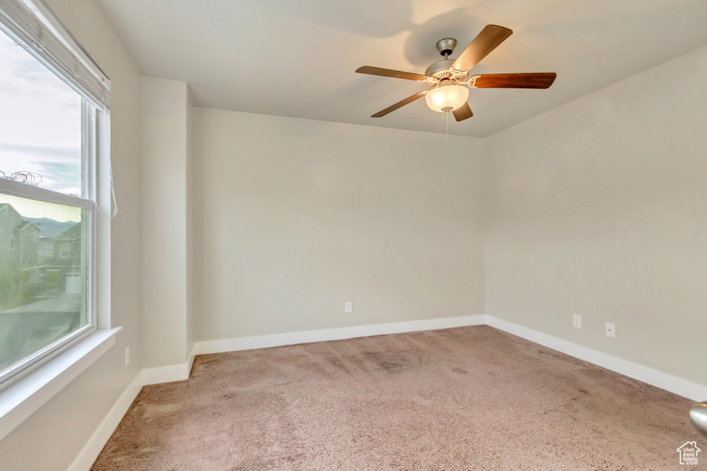 Empty room with carpet, ceiling fan, and baseboards