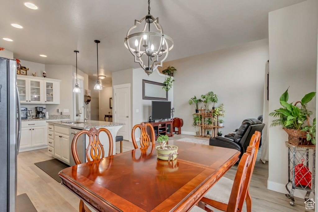 Dining area featuring light wood-style floors, recessed lighting, a chandelier, and baseboards