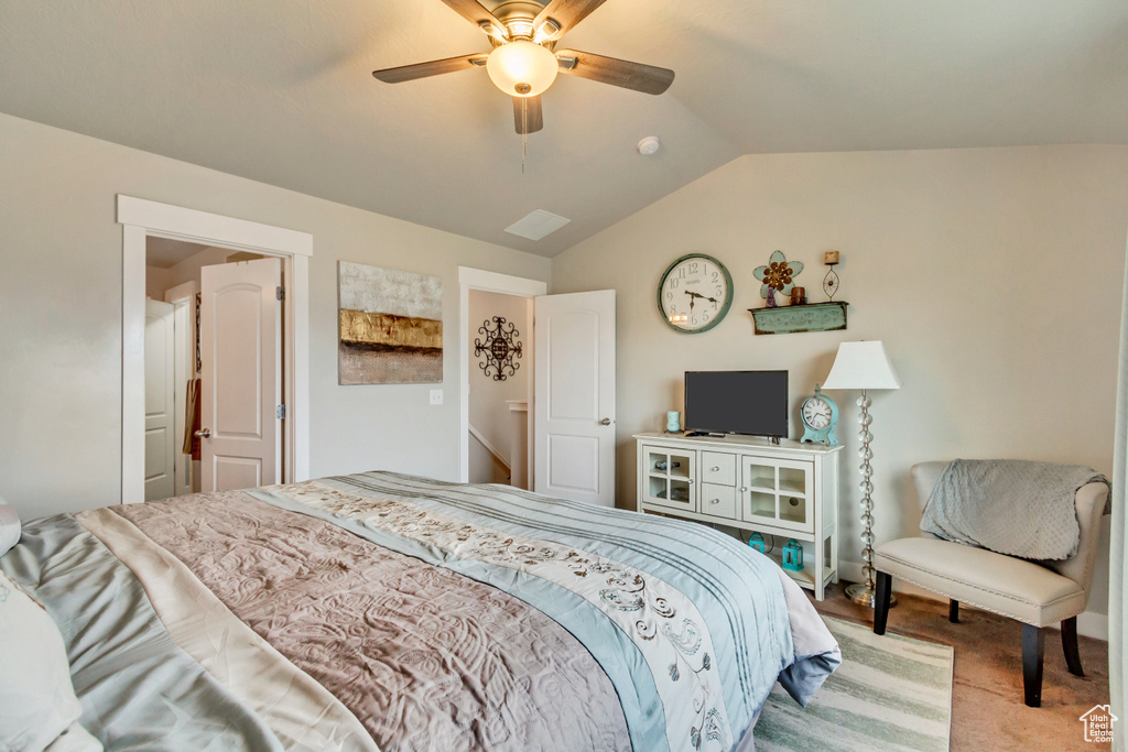 Carpeted bedroom featuring vaulted ceiling and ceiling fan