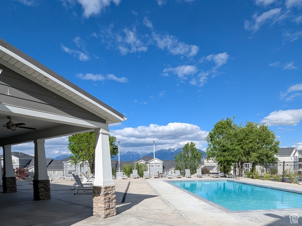 Community pool featuring a patio area, a ceiling fan, and a mountain view