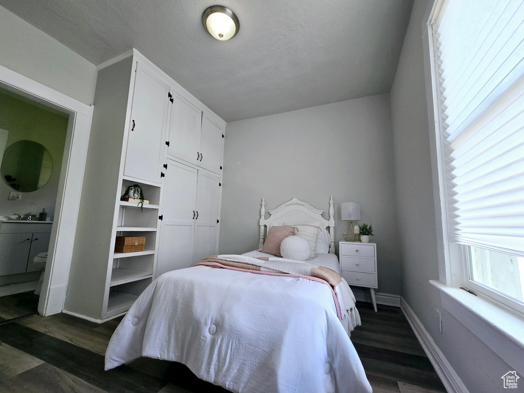 Bedroom featuring dark wood finished floors and baseboards