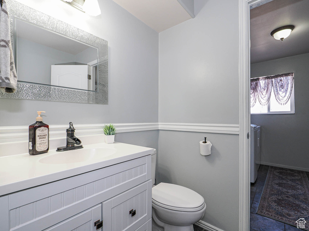 Bathroom with independent washer and dryer, vanity, and toilet