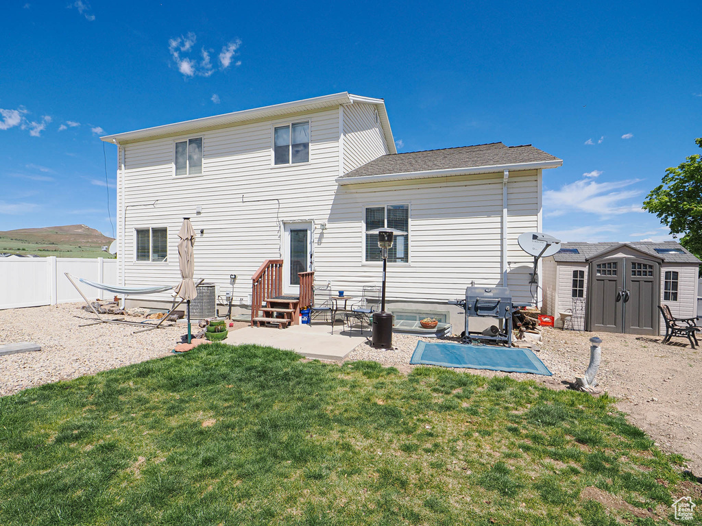 Rear view of house featuring a storage unit, a patio, an outbuilding, entry steps, and central AC