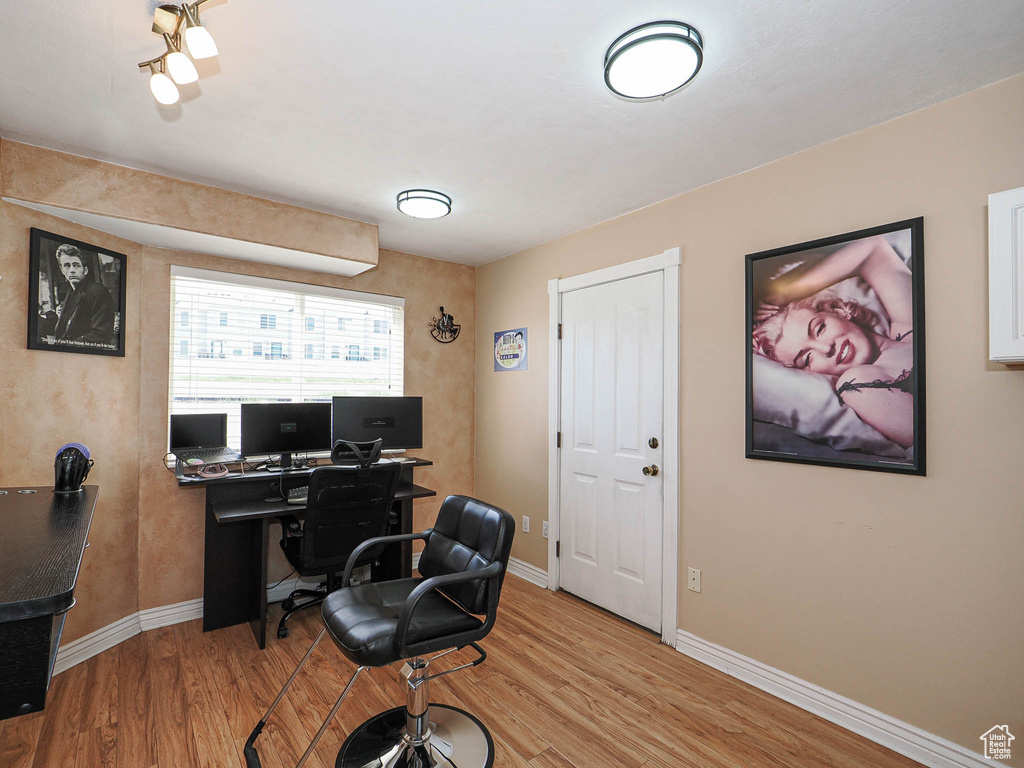 Office area featuring light wood-style flooring and baseboards