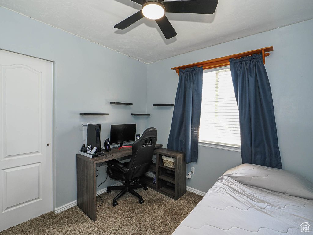Bedroom with carpet flooring, baseboards, a desk, and a ceiling fan