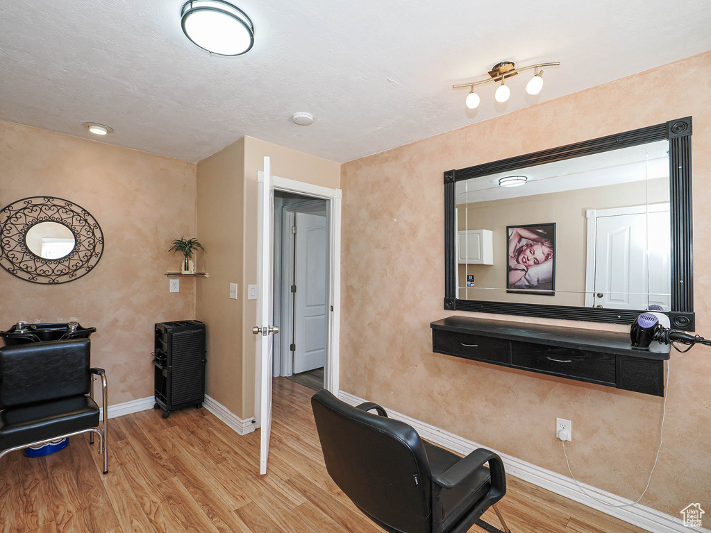 Exercise area with wood finished floors and baseboards