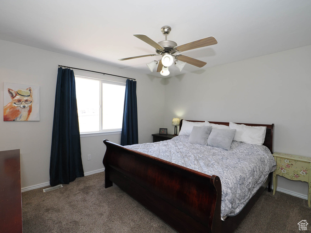 Carpeted bedroom featuring a ceiling fan and baseboards