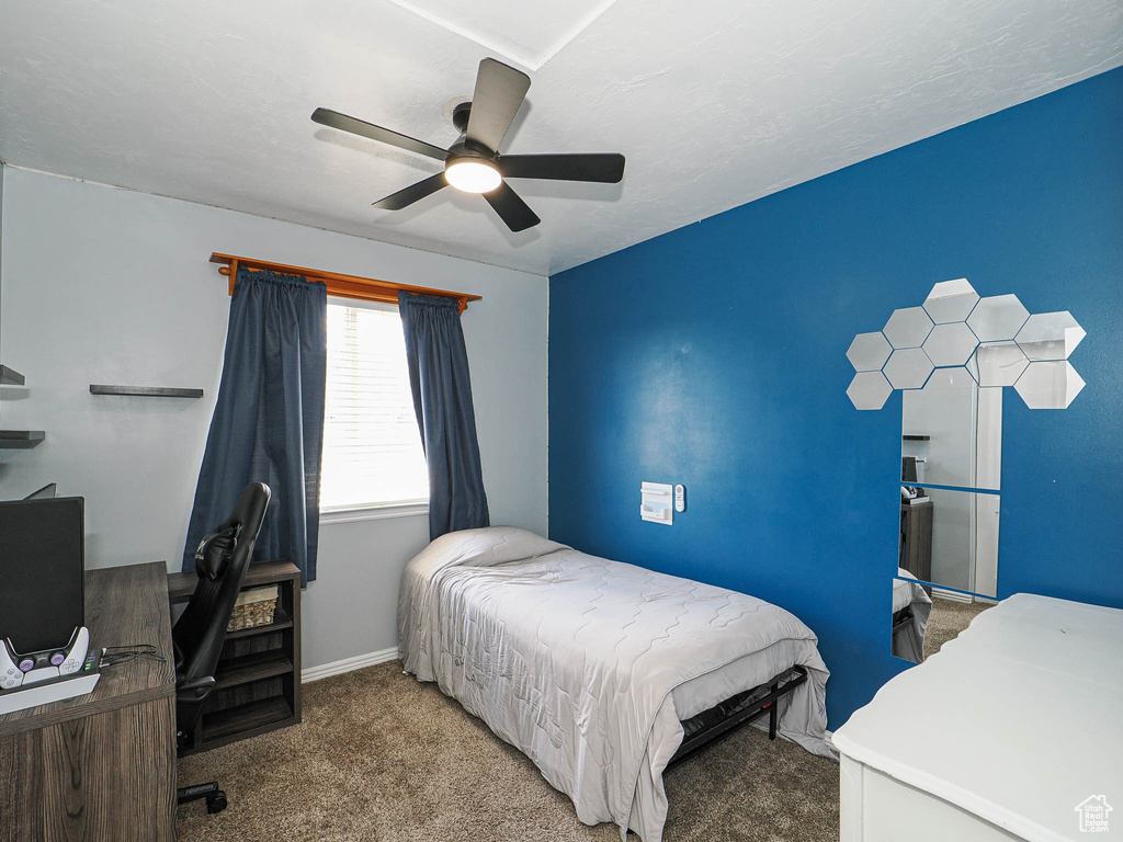 Bedroom featuring carpet, an office area, and a ceiling fan