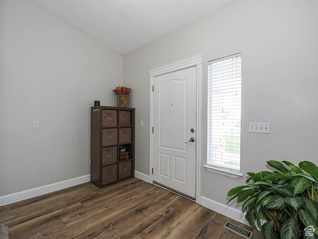 Foyer entrance with dark wood-type flooring and baseboards