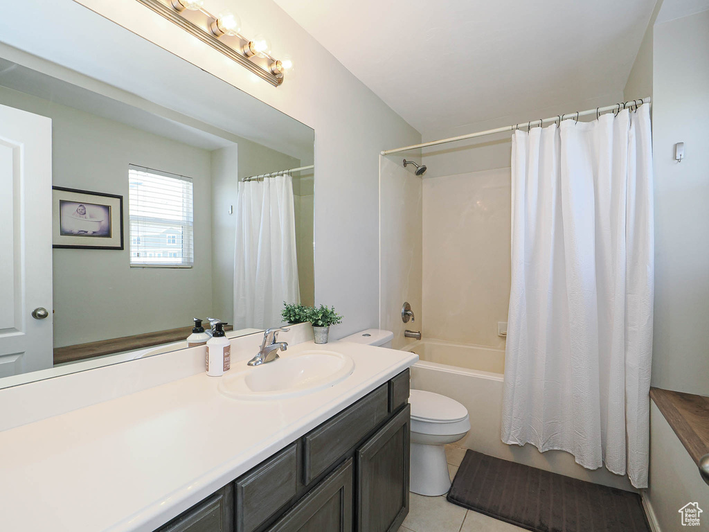 Bathroom with toilet, vanity, shower / bath combo, and tile patterned flooring