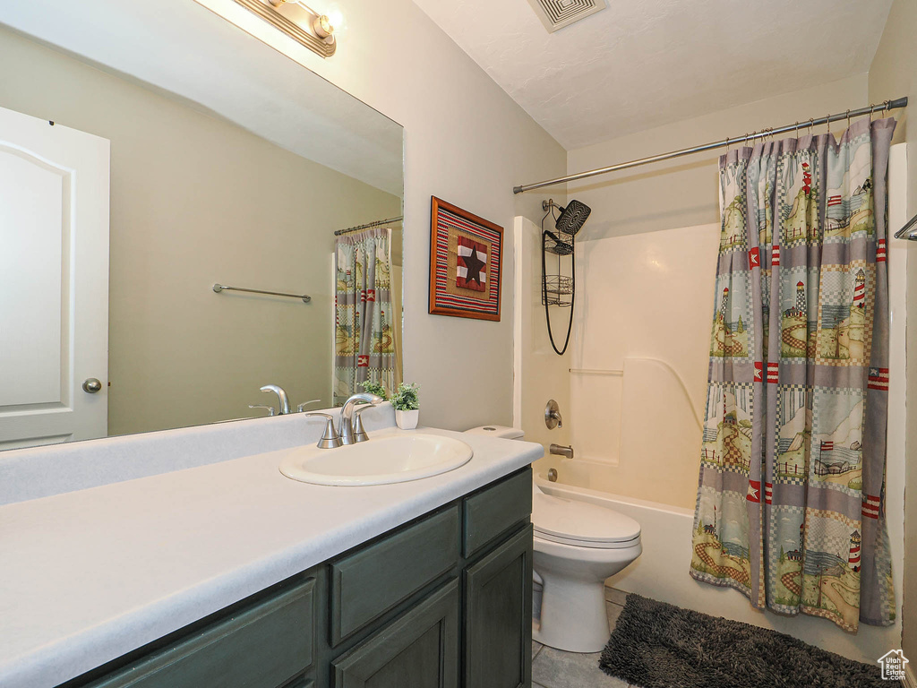 Full bath featuring tile patterned floors, vanity, shower / bathtub combination with curtain, and toilet