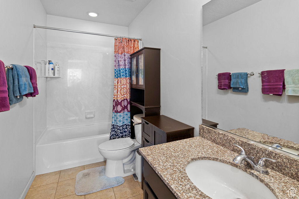Bathroom featuring toilet, shower / bath combo with shower curtain, tile patterned flooring, vanity, and recessed lighting
