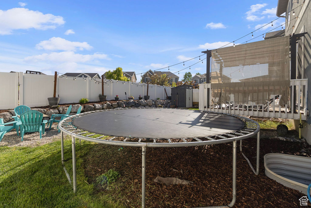 View of yard with a trampoline, a shed, and an outdoor structure