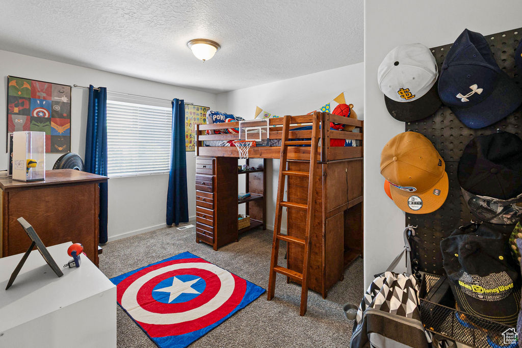 Bedroom with carpet floors, a textured ceiling, and baseboards