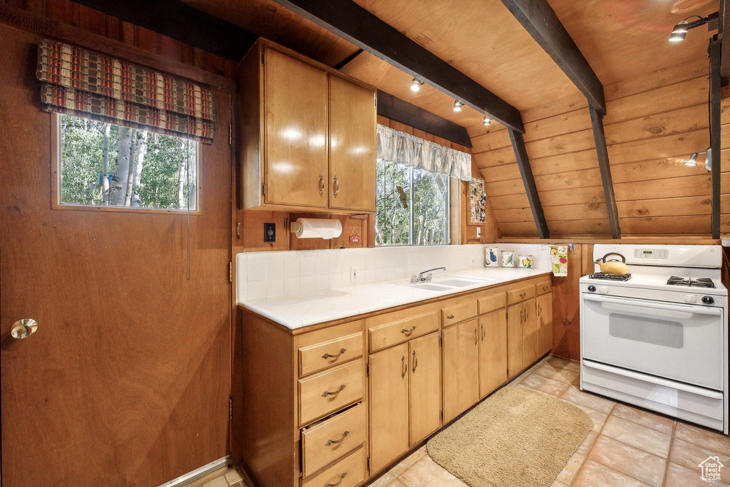 Kitchen featuring white range with gas cooktop, wood ceiling, a sink, and light countertops