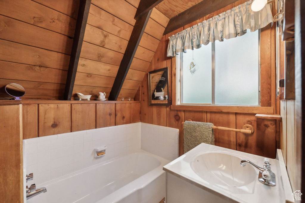 Full bathroom with wood ceiling, wooden walls, a sink, and a bath