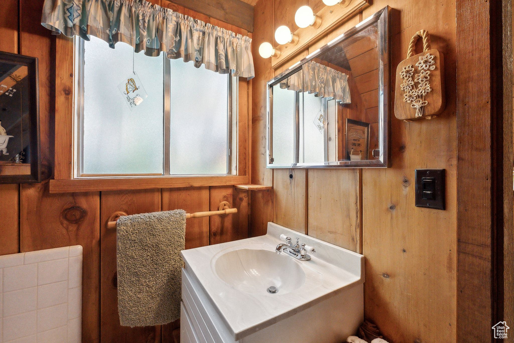 Bathroom featuring wood walls and vanity