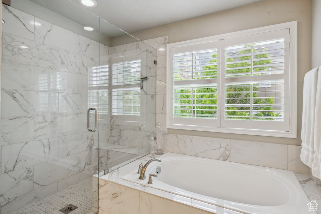 Bathroom with a bath and a marble finish shower