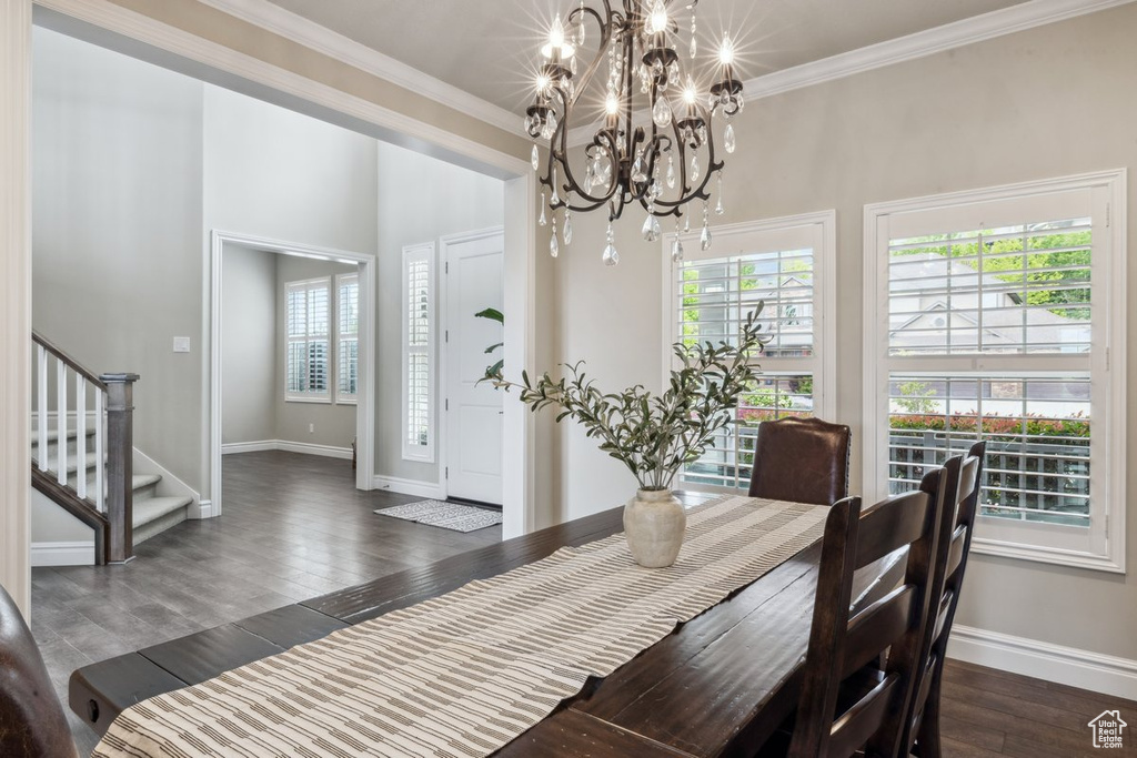 Dining room featuring ornamental molding, stairs, dark wood-style floors, a chandelier, and baseboards
