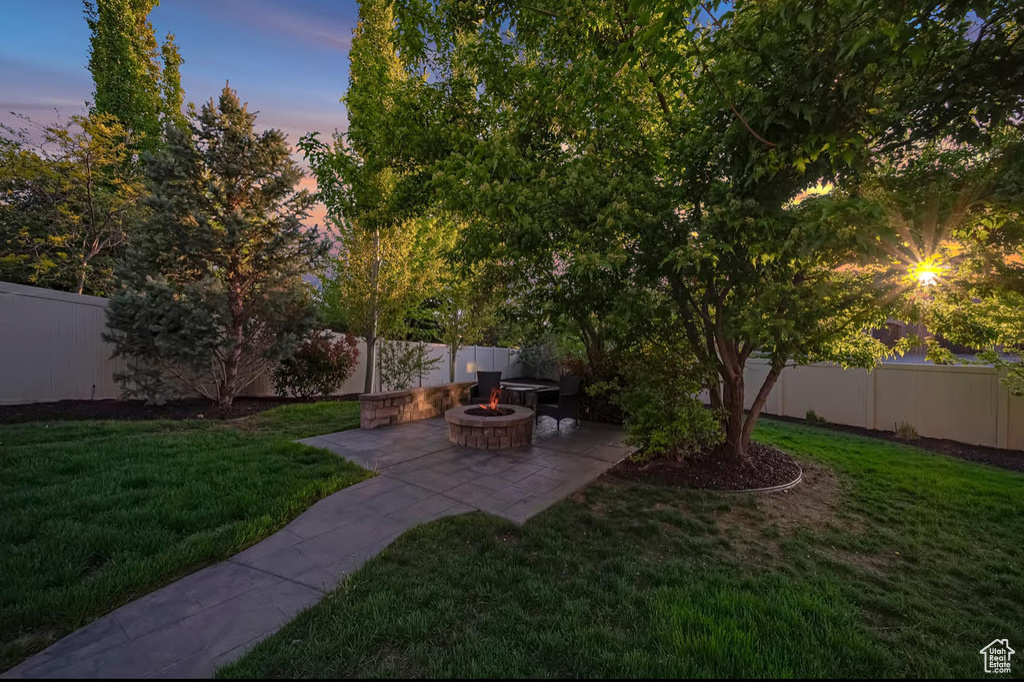 Fenced backyard with an outdoor fire pit and a patio area