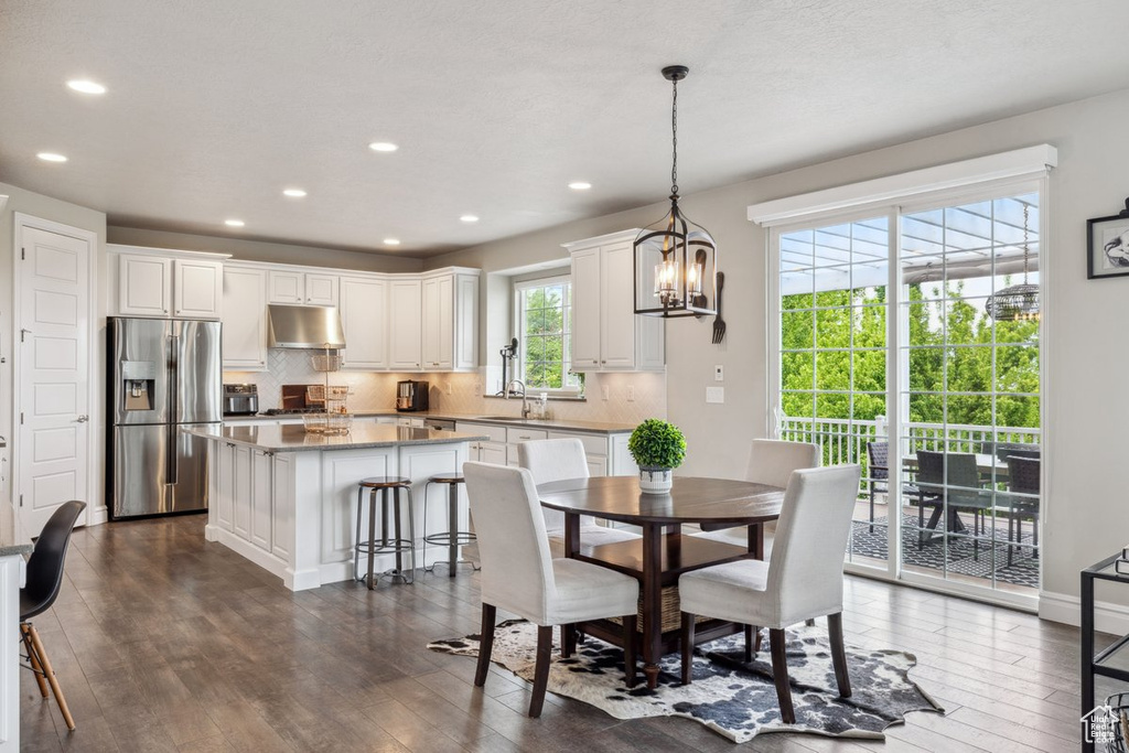Dining space with dark wood-style floors, recessed lighting, and a chandelier