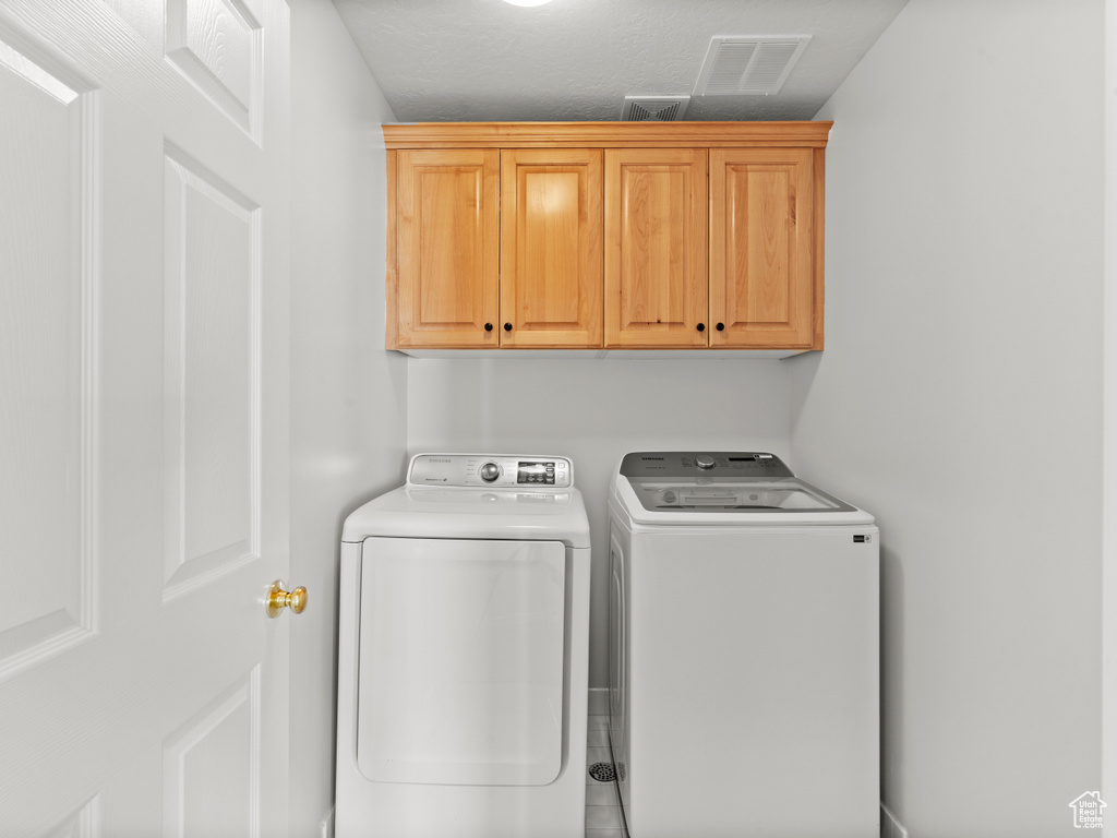 Clothes washing area with cabinet space and separate washer and dryer