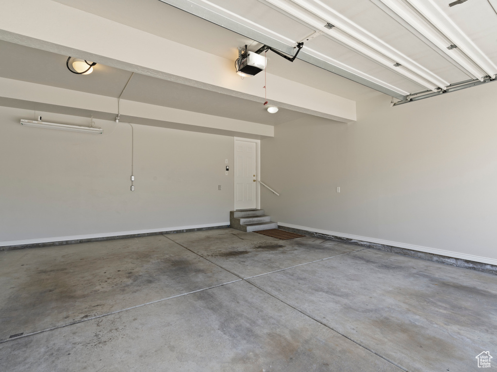 Garage with a garage door opener and baseboards