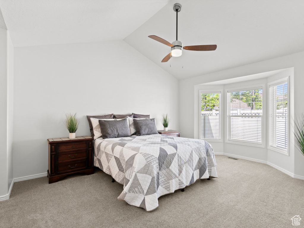 Bedroom with vaulted ceiling, carpet floors, ceiling fan, and baseboards