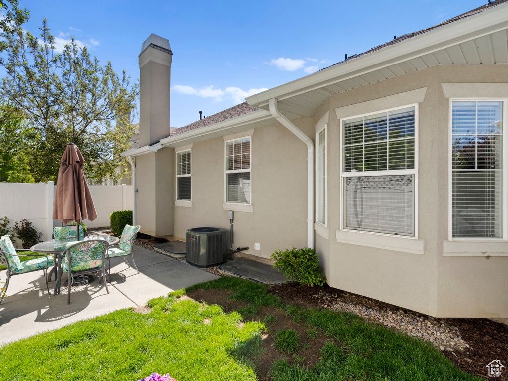 Back of house with a patio area, fence, a chimney, central AC, and stucco siding