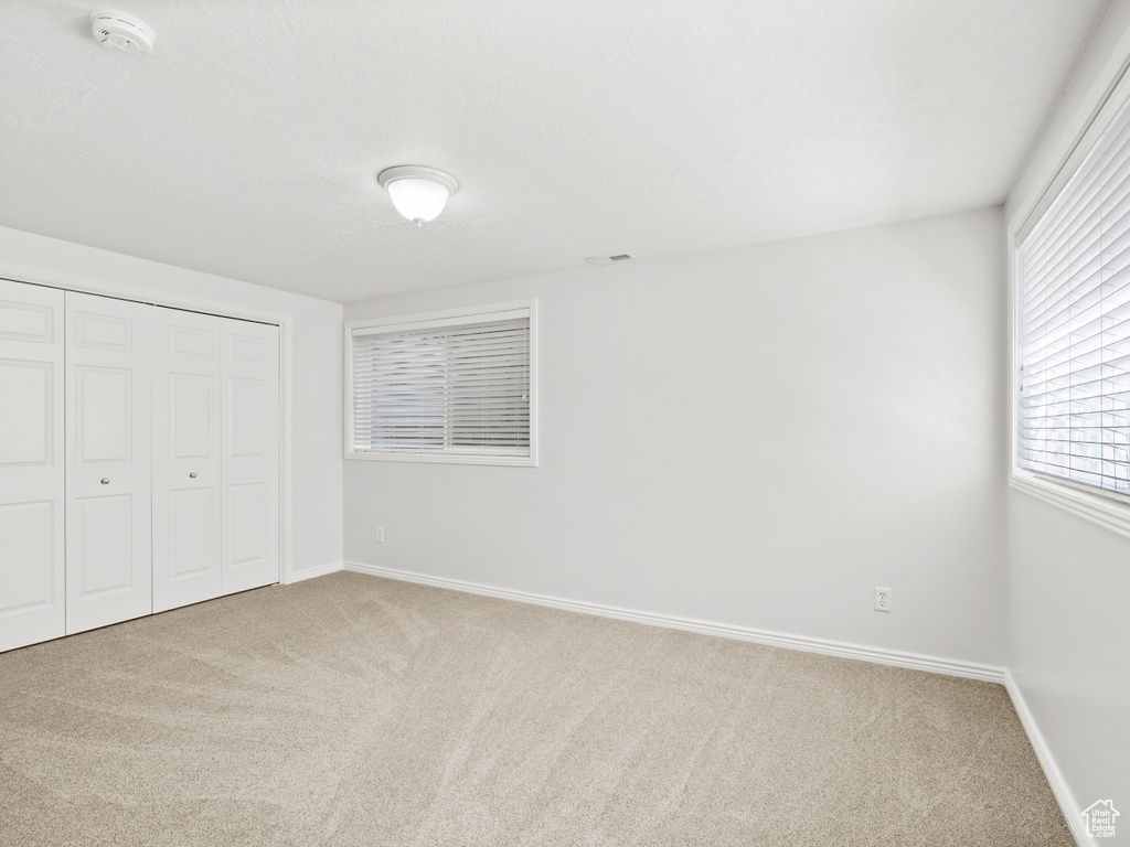 Unfurnished bedroom with carpet floors, baseboards, and a closet
