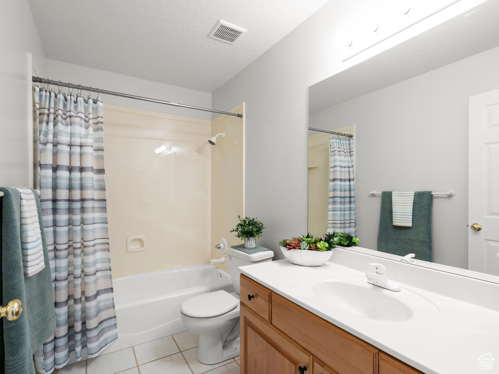Full bathroom featuring tile patterned floors, vanity, toilet, and shower / bathtub combination with curtain