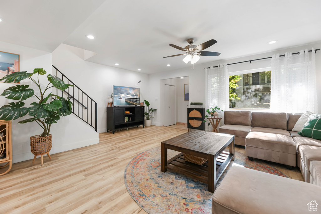 Living room featuring a ceiling fan, wood finished floors, stairway, recessed lighting, and baseboards