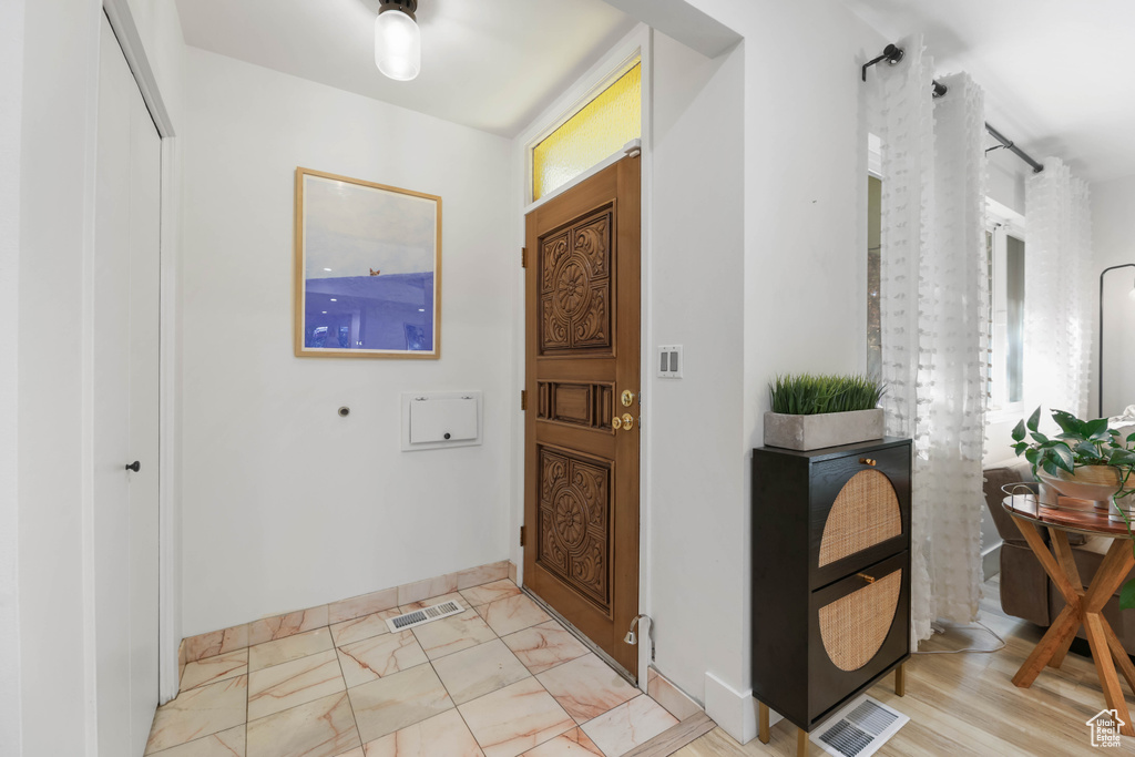 Foyer entrance featuring baseboards and light marble finish floors