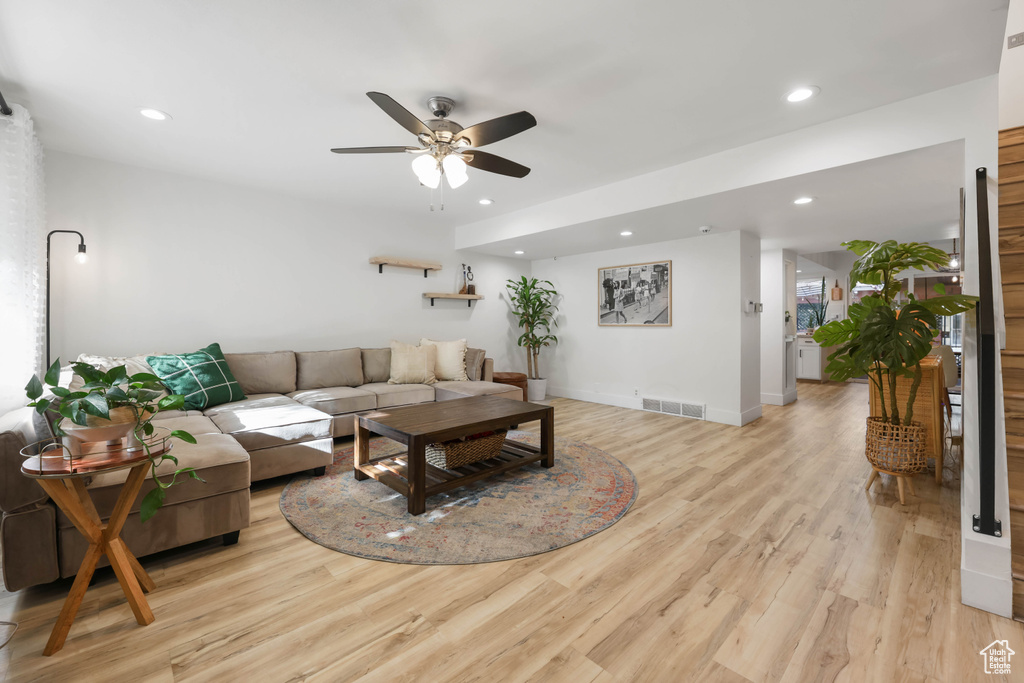 Living room with a ceiling fan, recessed lighting, light wood-style flooring, and baseboards