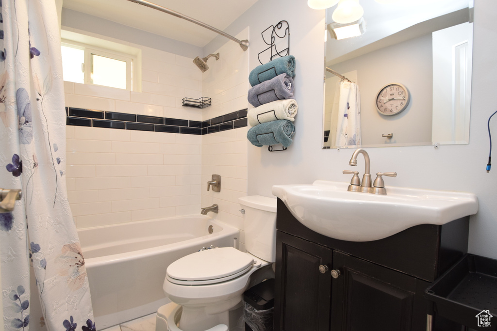 Bathroom featuring toilet, vanity, and shower / tub combo with curtain