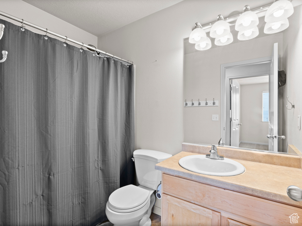 Full bathroom with vanity, toilet, and a shower with shower curtain