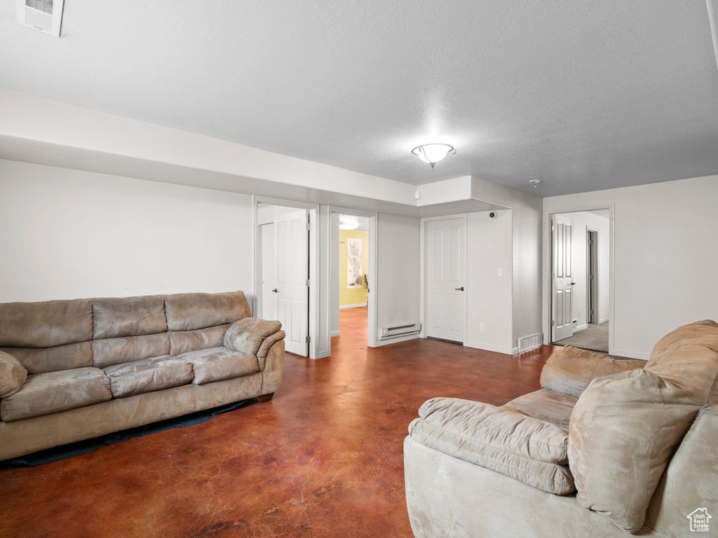 Living room featuring a baseboard radiator, finished concrete floors, and baseboards