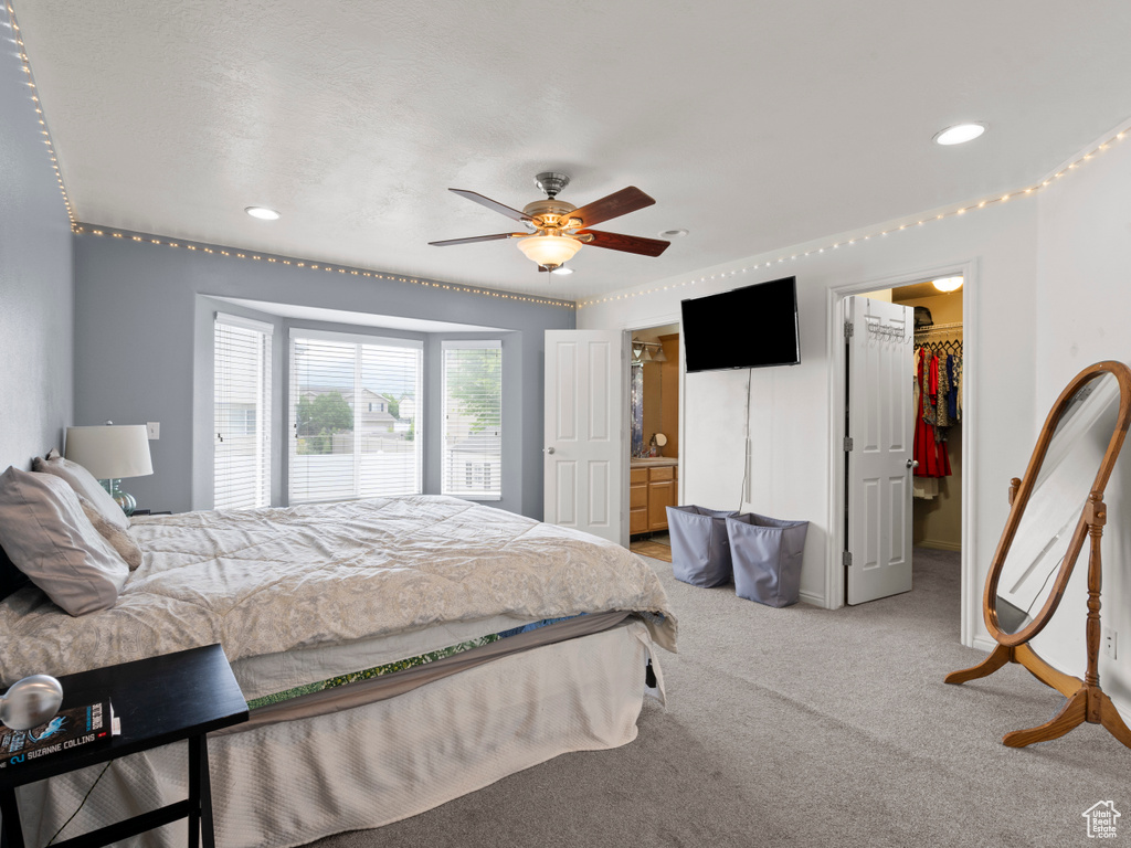Bedroom with a walk in closet, light carpet, ceiling fan, recessed lighting, and a closet