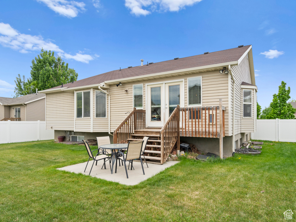 Back of property featuring a wooden deck and a patio area