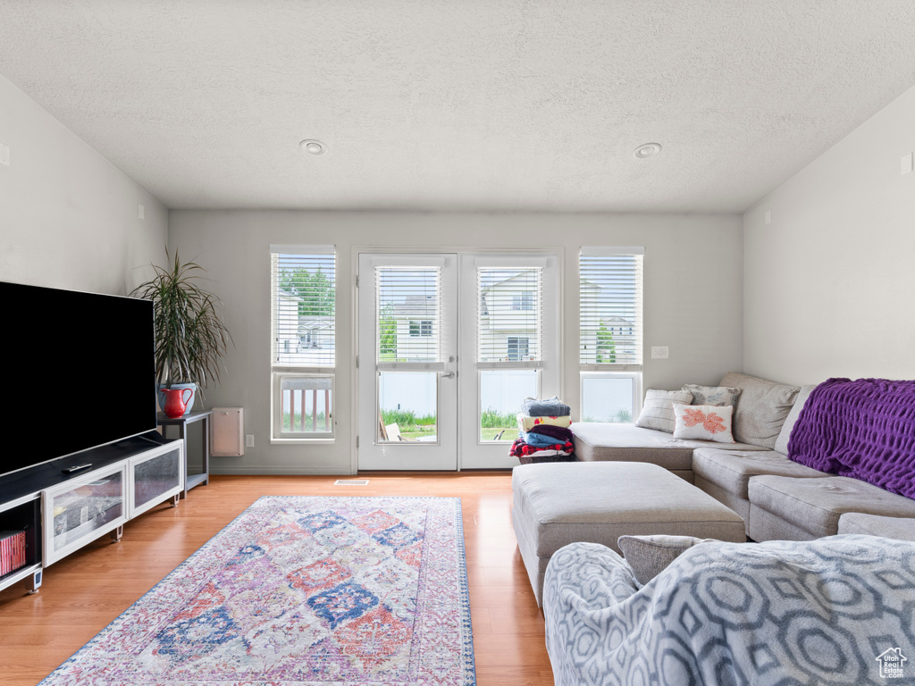 Living room with a textured ceiling and wood finished floors