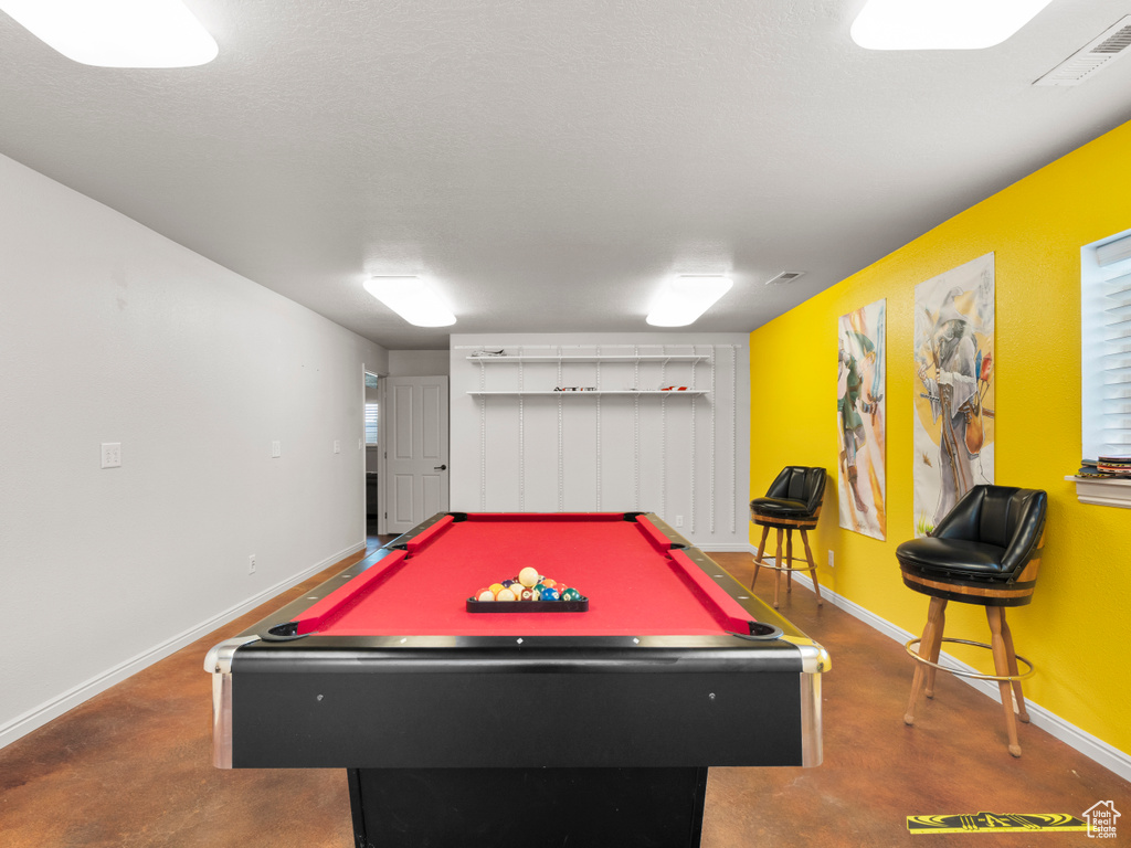 Recreation room featuring baseboards, pool table, and concrete floors