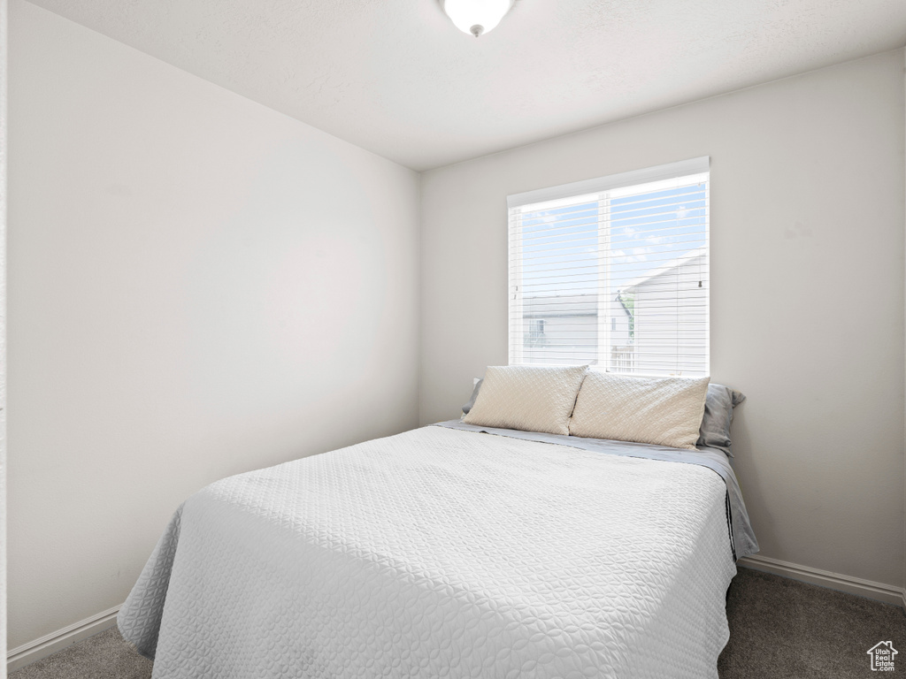 Bedroom featuring carpet flooring and baseboards