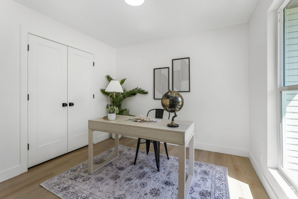 Office area with light wood-style floors and baseboards
