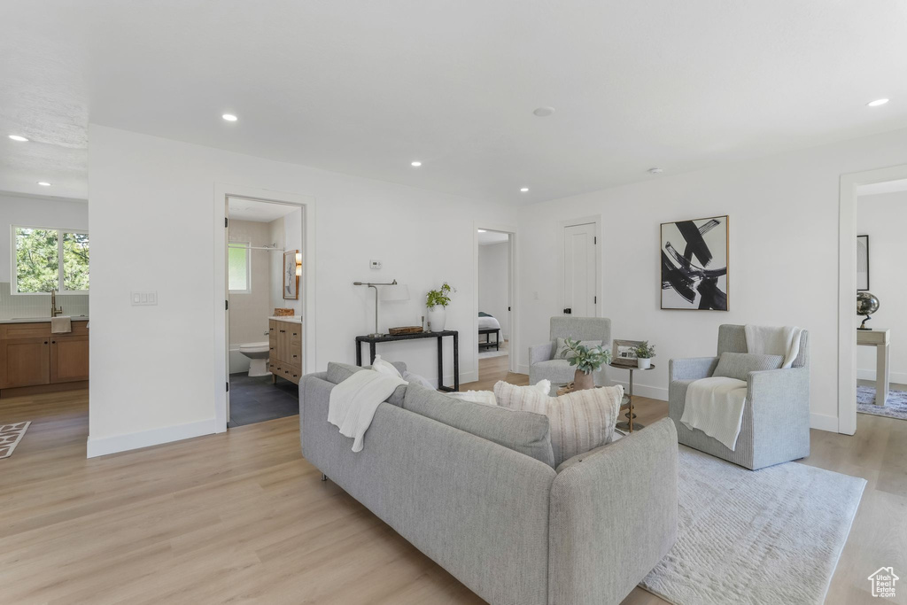 Living area with light wood finished floors, recessed lighting, and baseboards