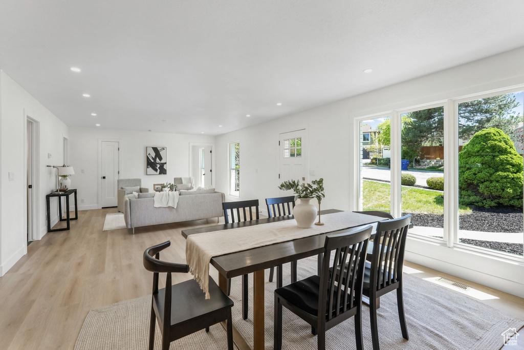 Dining room with light wood-type flooring and recessed lighting