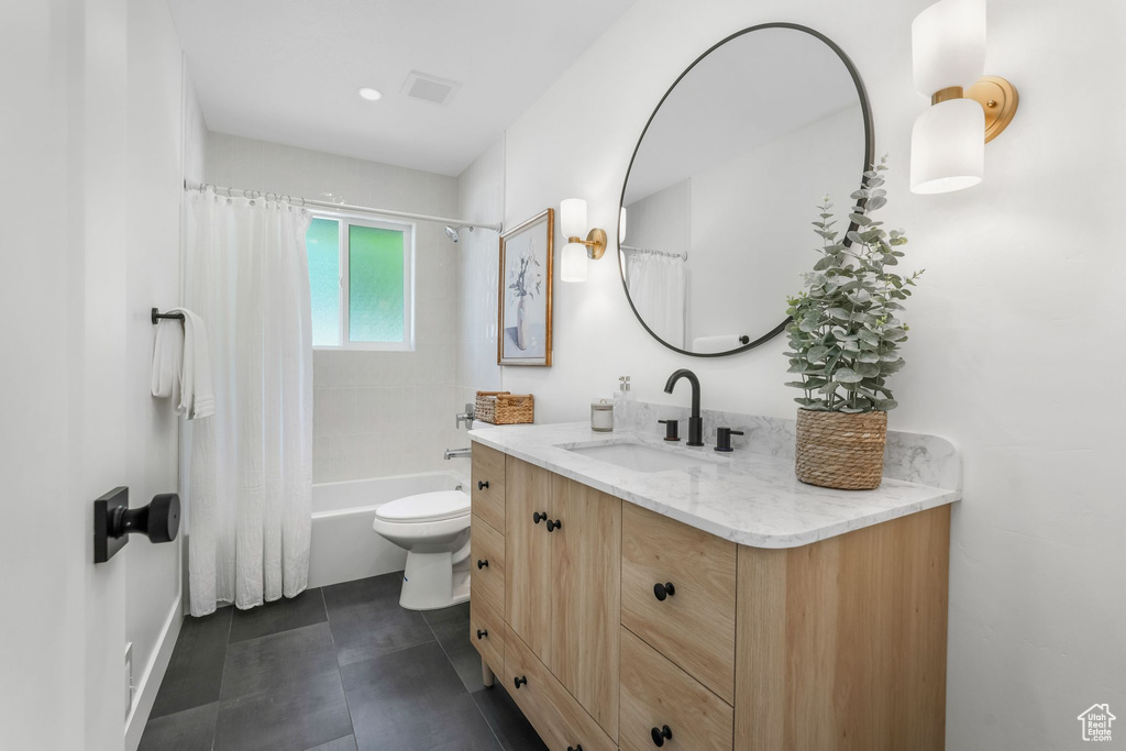 Bathroom featuring vanity, toilet, and shower / bath combo