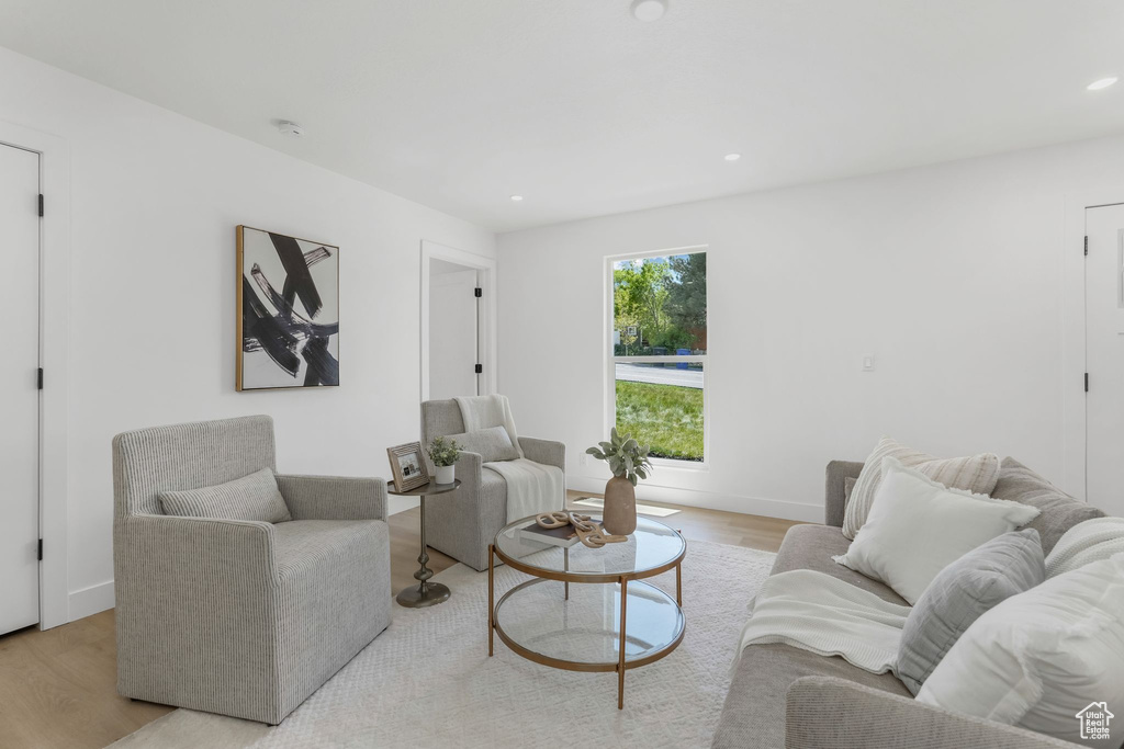 Living room with light wood-style floors, recessed lighting, and baseboards
