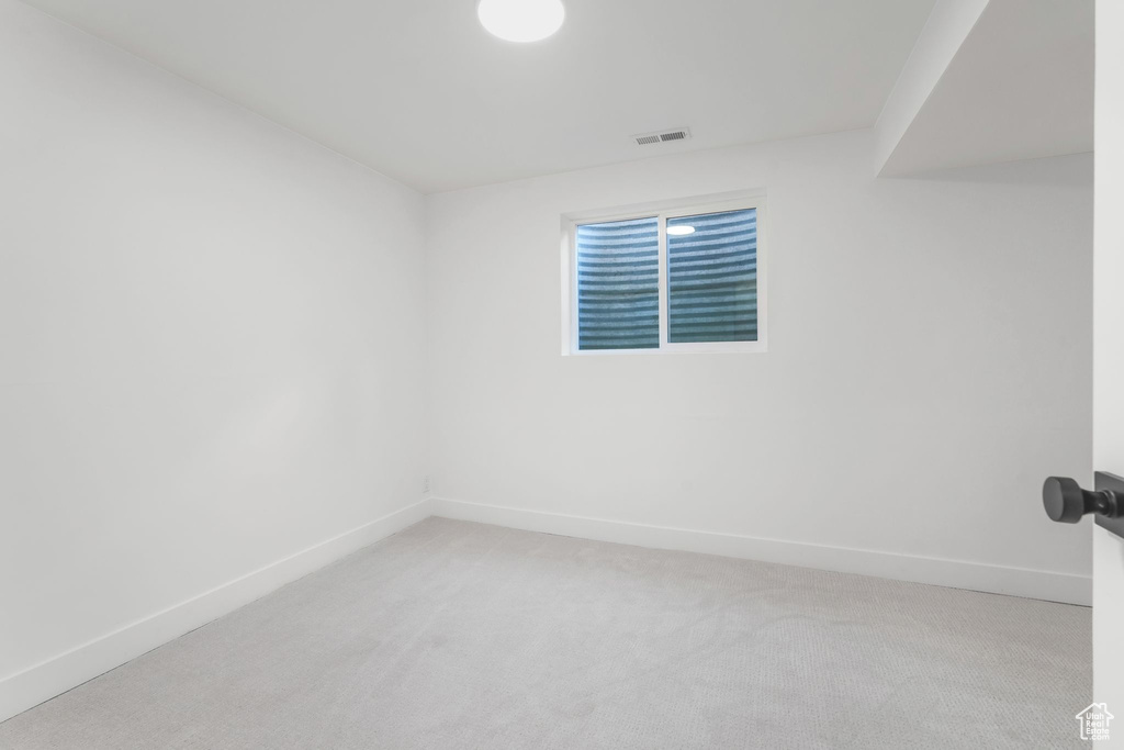 Unfurnished room featuring baseboards and light colored carpet